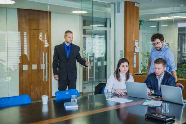 man-entering-room-with-coworkers