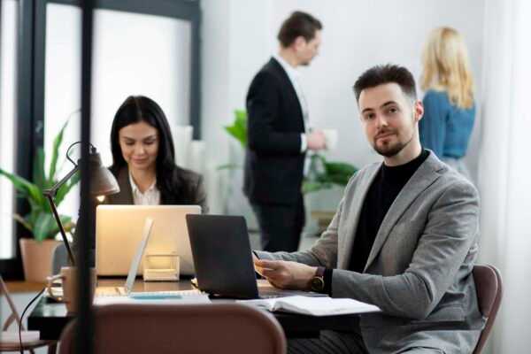 a person sitting in the table with laptop and looking in front